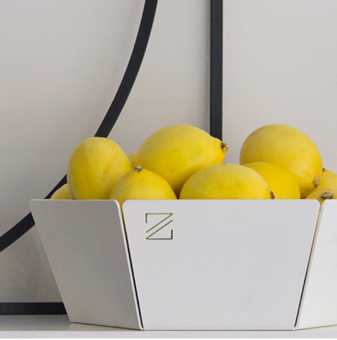 The white fruit bowl jut by ZOOI filled with lemons. A modern home kitchen bowl.