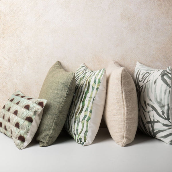 Five cushions by Urban Nature Culture against a beige background.